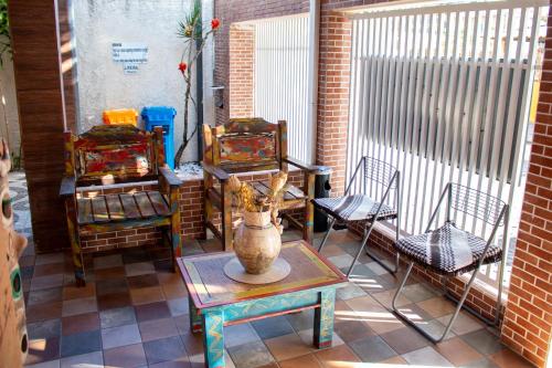 un patio con sillas y un jarrón sobre una mesa en Pousada Innova, en Natal