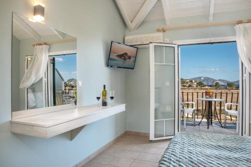 a bathroom with a tub and a tv on the wall at Herodotos Studios in Keri