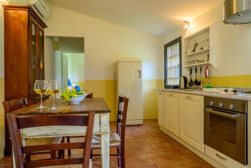 a kitchen with a table and chairs and a refrigerator at Podere Vigliano in Tavarnelle in Val di Pesa