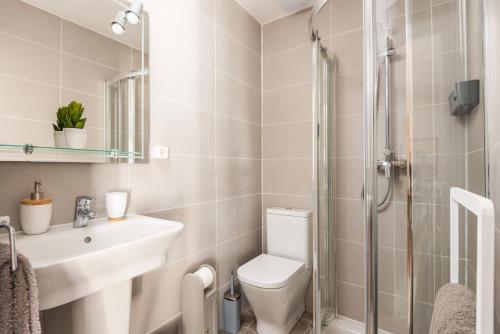 a bathroom with a toilet and a sink and a shower at Casa Blanca - villa con piscina a 30m del mar-Binibeca in Sant Lluis