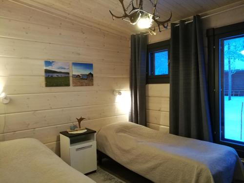a bedroom with two beds and a window at Lomatärppi in Utsjoki