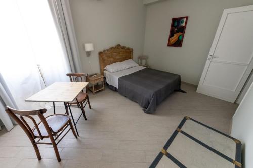 sypialnia z łóżkiem i stołem z krzesłami w obiekcie " DOMUS CORALLA" BnB Racconti Di Viaggio w Katanii