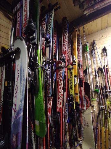 a bunch of skis and snowboards are hanging on a wall at Вотавілю Драгобрат in Dragobrat