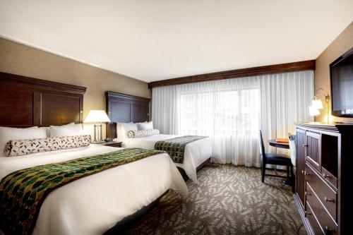 a hotel room with two beds and a desk at Glenwood Hot Springs Resort in Glenwood Springs