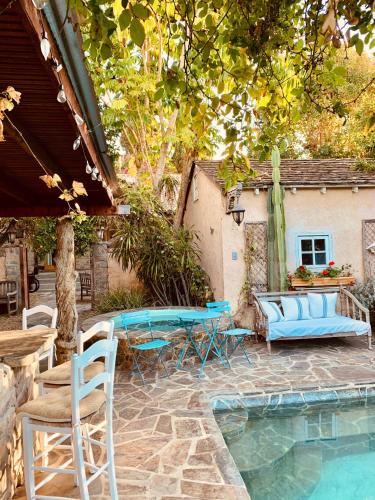 a patio with a table and chairs next to a pool at Under the Tuscan Sun Cottage in West Los Angeles in Los Angeles