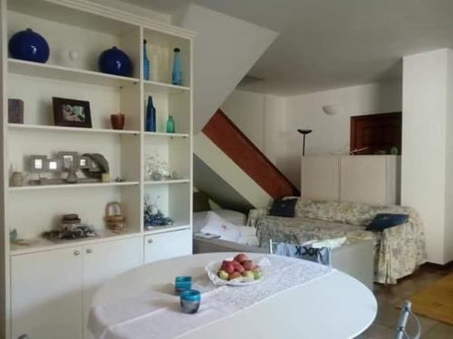 una sala de estar con una mesa con un bol de fruta en Room Villa Sole, en Termoli