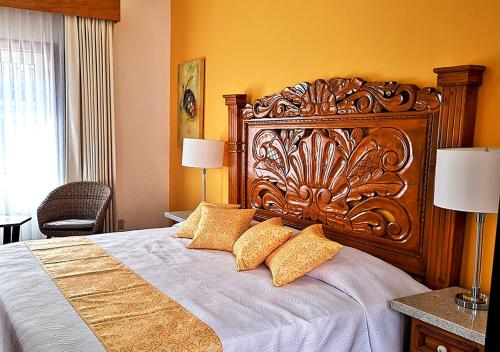 a bedroom with a large wooden bed with two pillows at Casa Carmen in Puerto Vallarta
