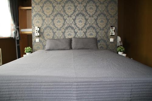 - un grand lit dans une chambre dotée d'un mur bleu dans l'établissement Het Populierennest, à Middelkerke
