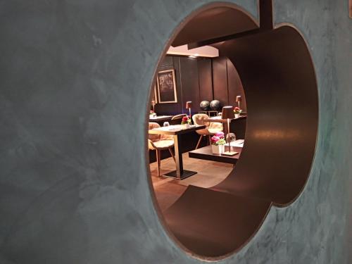 a circular mirror in a room with a table and chairs at Hotel Royal Falcone in Monza