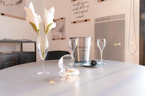 a white table with two wine glasses and a silver bucket at Au Charm'Sablais in Les Sables-dʼOlonne