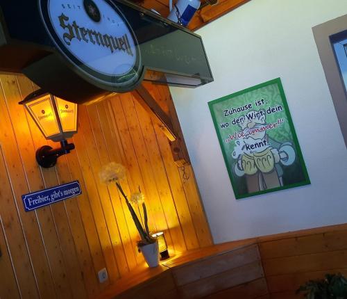 a clock hanging on a wall with a sign on it at Gasthof zur Linde in Pausa