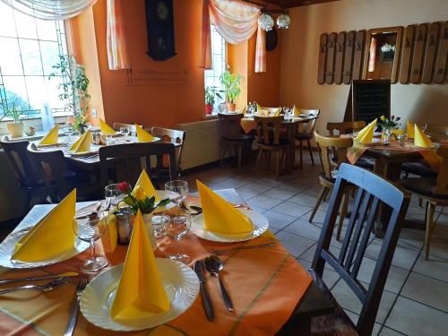 a dining room with tables with yellow napkins on them at Gasthof zur Linde in Pausa