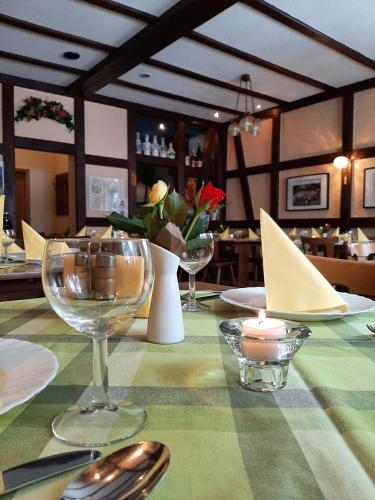 a table with a green table cloth with wine glasses at Gasthof zur Linde in Pausa