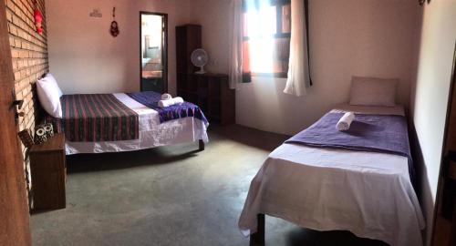 um quarto com duas camas e um espelho em Pousada Pico Da Vila em Vale do Capão