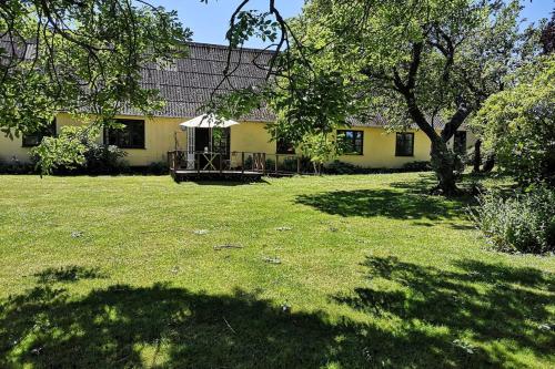 a yellow house with a yard with a tree at Foxhouse in Præstø