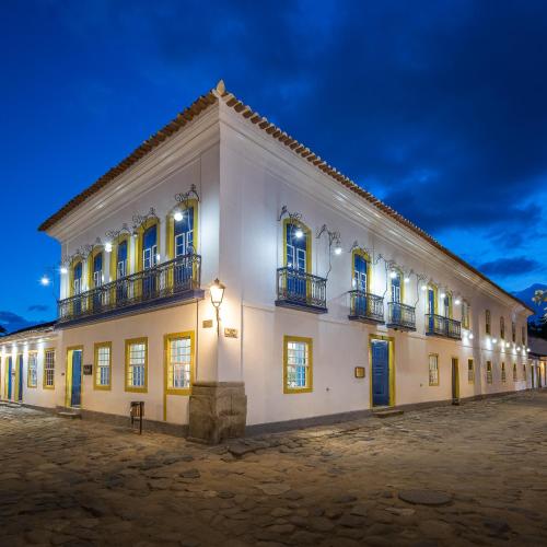 ein großes weißes Gebäude mit Fenstern und Balkonen in der Nacht in der Unterkunft Sandi Hotel in Paraty