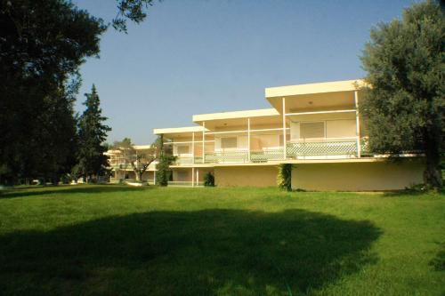 a large building with a large lawn in front of it at Palmariva Beach Hotel in Eretria