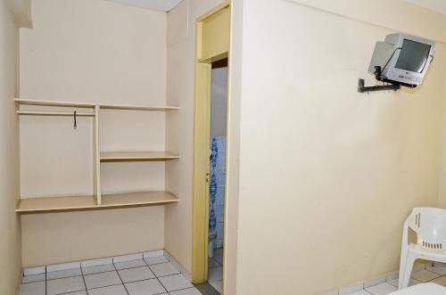 una habitación con estanterías y TV en la pared en Natal Palace Hotel, en Natal