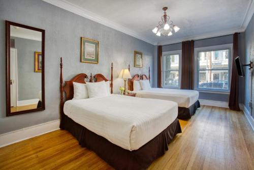 a hotel room with two beds and a mirror at MarQueen Hotel in Seattle