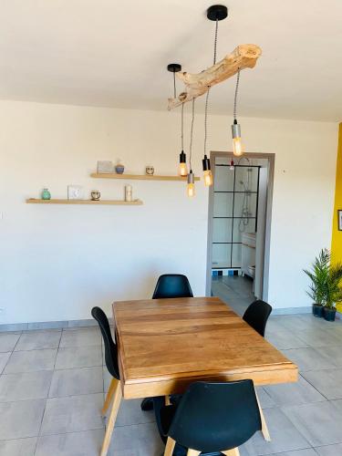 a dining room with a wooden table and chairs at Face a la mer Fleury in Fleury