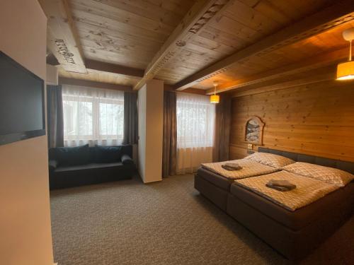 a bedroom with a bed and a couch in a room at Pension Marina in Tux