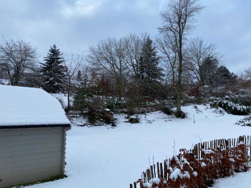 a fence covered in snow next to a house at Le Retour aux Sources - Chambre d'Hôte chaleureuse et conviviale in Chaudfontaine