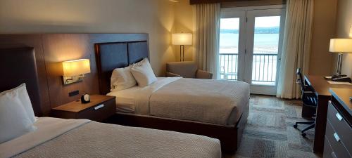 ベルファストにあるBelfast Harbor Innのベッド2台とバルコニーが備わるホテルルームです。