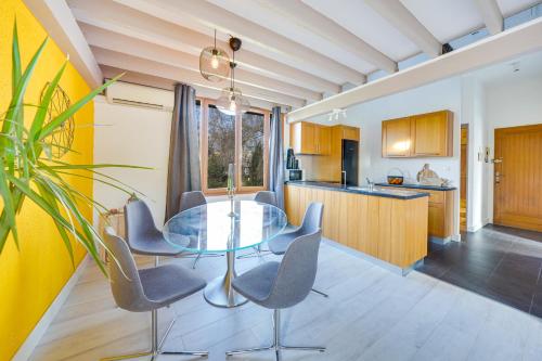 une cuisine avec une table et des chaises en verre dans l'établissement Bel appart pour 6 p, clim, parking et terrasse, à Aix-en-Provence