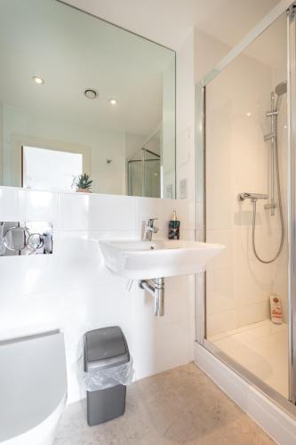 a white bathroom with a sink and a shower at Spacious City Center Apartment By Smart Apartments Short Lets & Serviced Accommodation Apartment Southampton With Free WiFi in Southampton