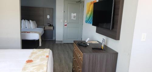 a hotel room with a bed and a flat screen tv at Hawthorn Extended Stay by Wyndham Panama City Beach in Panama City Beach