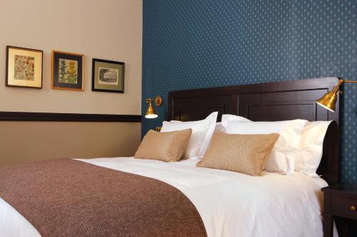 a bedroom with a large bed with white sheets and pillows at Hotel Boutique Castillo Rojo in Santiago