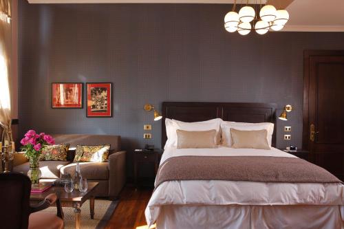 a bedroom with a bed and a couch at Hotel Boutique Castillo Rojo in Santiago