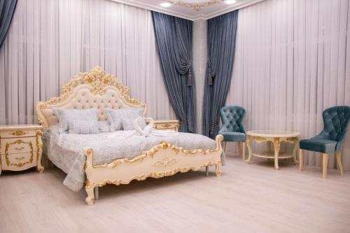 a bedroom with a bed and two chairs and a table at Fidan Hotel in Simferopol