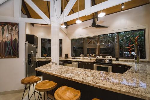 a kitchen with a large counter and some stools at Tulemar Resort in Manuel Antonio