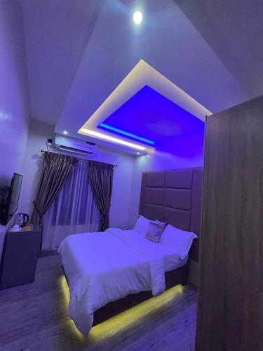 a bedroom with a bed with a purple lighting at God's Touch Apartments Signature in Lagos