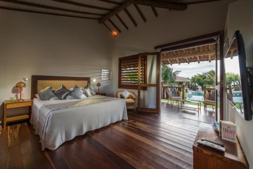 um quarto com uma cama e vista para o oceano em Vila Selvagem Hotel Contemporaneo em Fortim