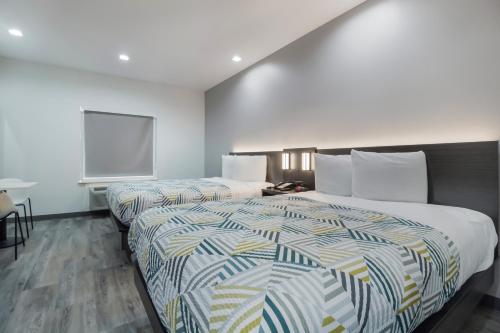 a hotel room with two beds and a window at Studio 6 Katy, Tx in Katy