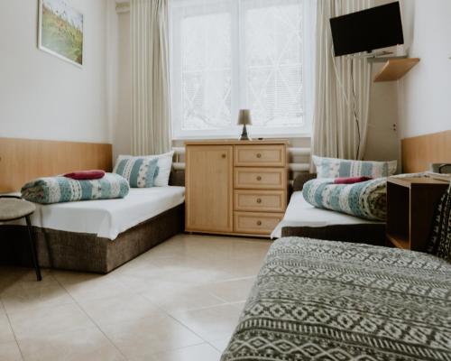 a hotel room with two beds and a tv at Camping nr 61 in Elblag