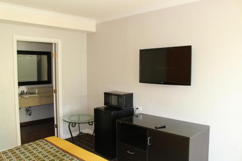 a hotel room with a bed and a flat screen tv at LYFE INN & SUITES by AGA - LAX Airport in Inglewood
