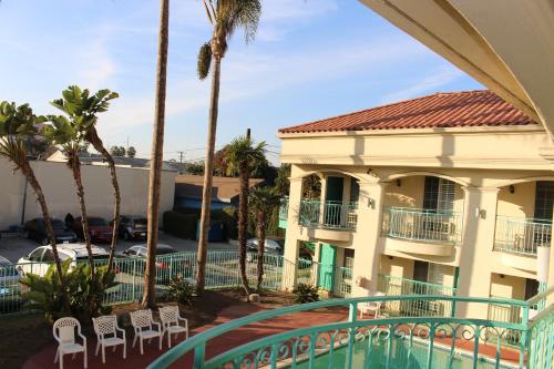 a view of a building with palm trees and a swimming pool at LYFE INN & SUITES by AGA - LAX Airport in Inglewood