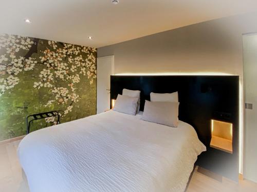 a bedroom with a large white bed with a flower mural at LA GLORIETTE in Marche-en-Famenne