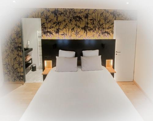 a large white bed with two pillows in a bedroom at LA GLORIETTE in Marche-en-Famenne