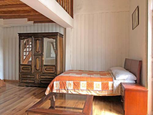 a bedroom with a bed and a dresser at Hostal Latina in Cuenca