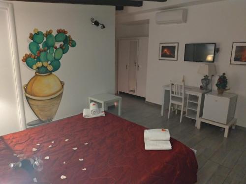 
a room with a bed, a table, and a painting on the wall at B&B My Sicily in Giardini Naxos
