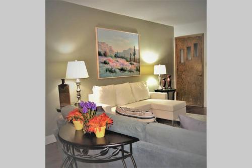 sala de estar con sofá y mesa con flores en Arhaus 3 en Grand Forks