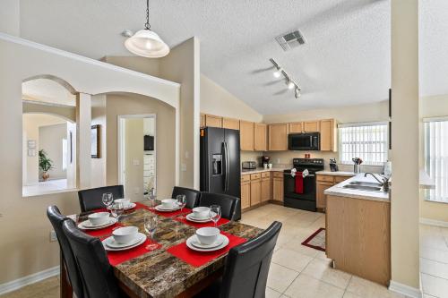 a kitchen and dining room with a table and chairs at South Facing Pool Deck - Private Outlook - Game Room - Family Friendly - Nr Disney in Orlando