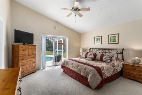 a bedroom with a bed and a television and a dresser at South Facing Pool Deck - Private Outlook - Game Room - Family Friendly - Nr Disney in Orlando