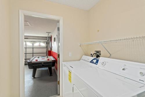 a laundry room with a ping pong table in a room at South Facing Pool Deck - Private Outlook - Game Room - Family Friendly - Nr Disney in Orlando