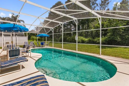 a swimming pool with chairs and umbrellas and a swimming poolvisor at South Facing Pool Deck - Private Outlook - Game Room - Family Friendly - Nr Disney in Orlando