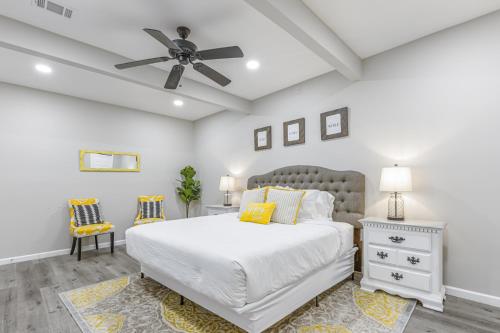 a bedroom with a white bed and a ceiling fan at Explore Historic DT In This Cozy Open Air 5BR Stay in Cartersville